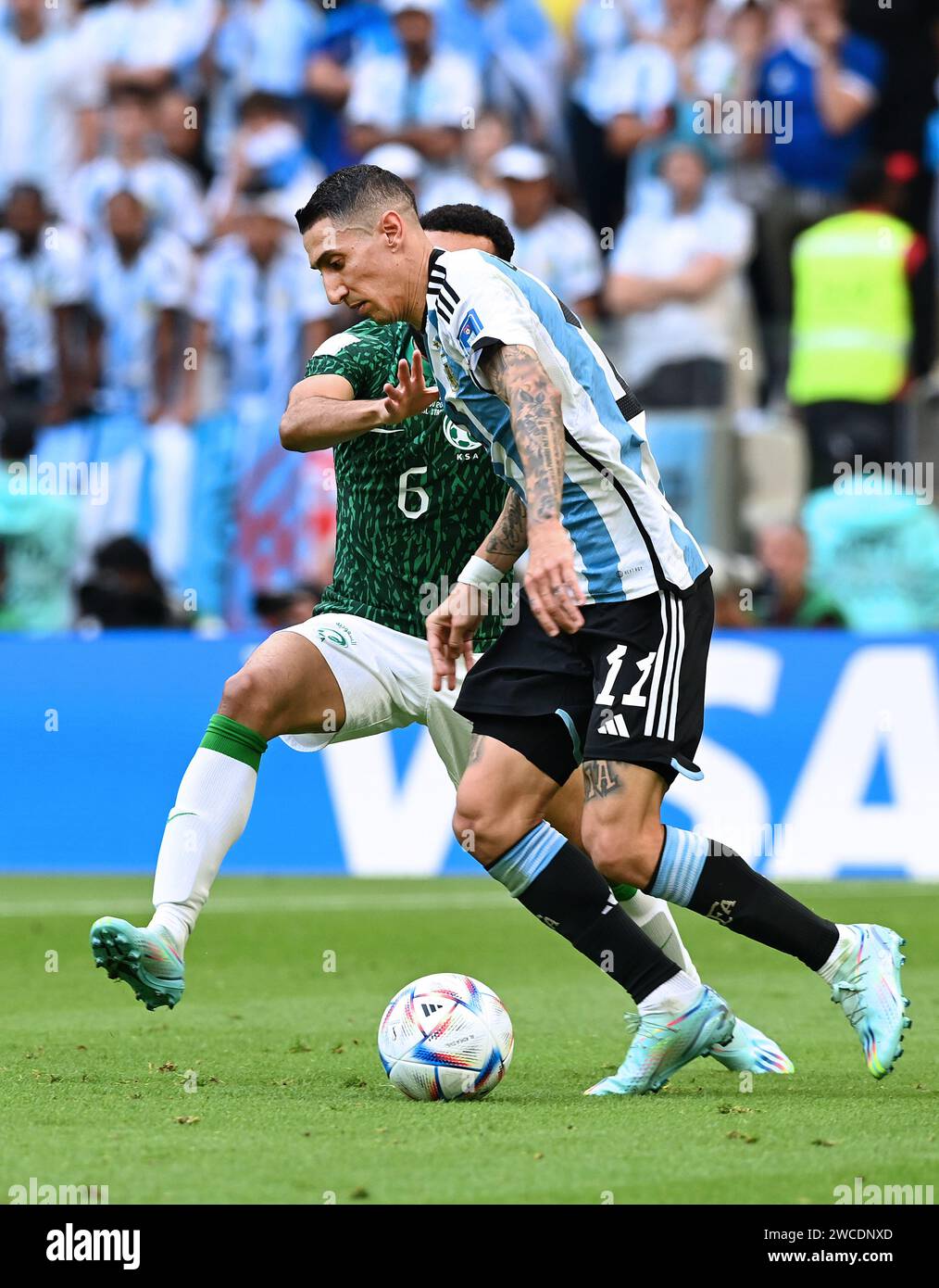 Ángel Di María attempts to dribble past Saudi Arabian defender, Mohammed Al-Burayk, during Argentina's Group Stage loss in the 2022 FIFA World Cup. Stock Photo