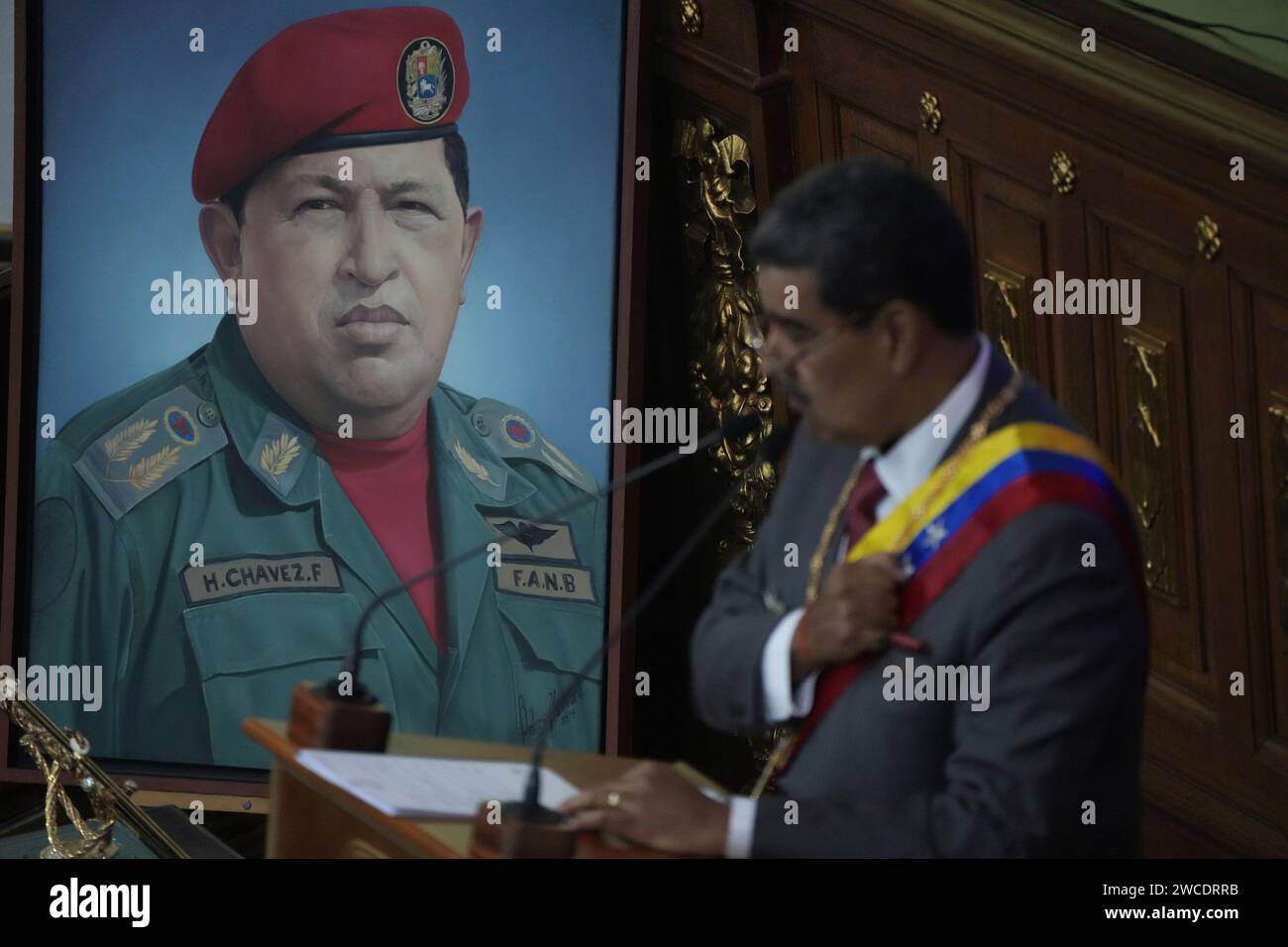 An image of late President Hugo Chavez stands behind Venezuelan ...