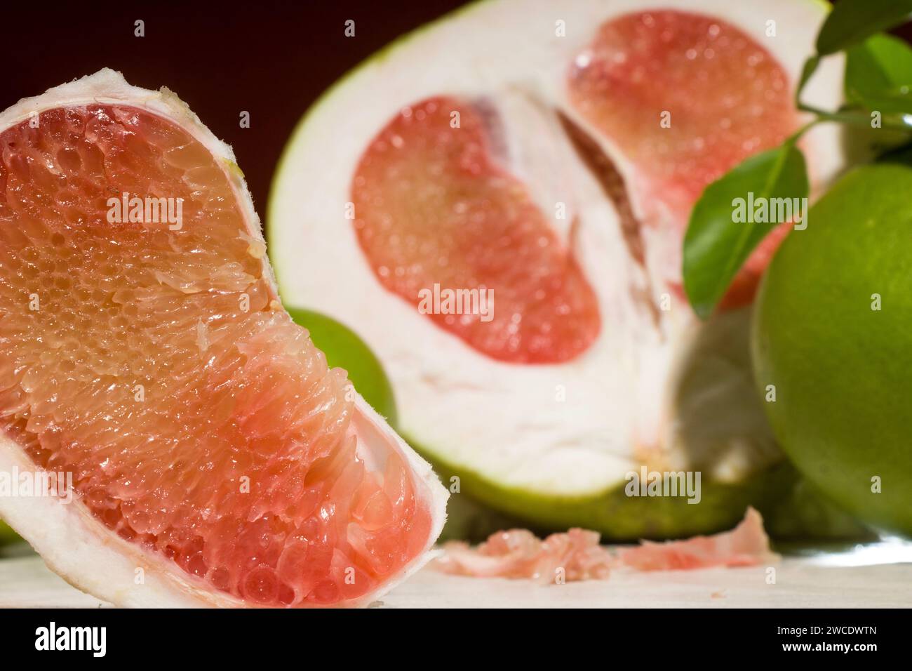 pieces of red Pomelo fruit on an orange background Stock Photo