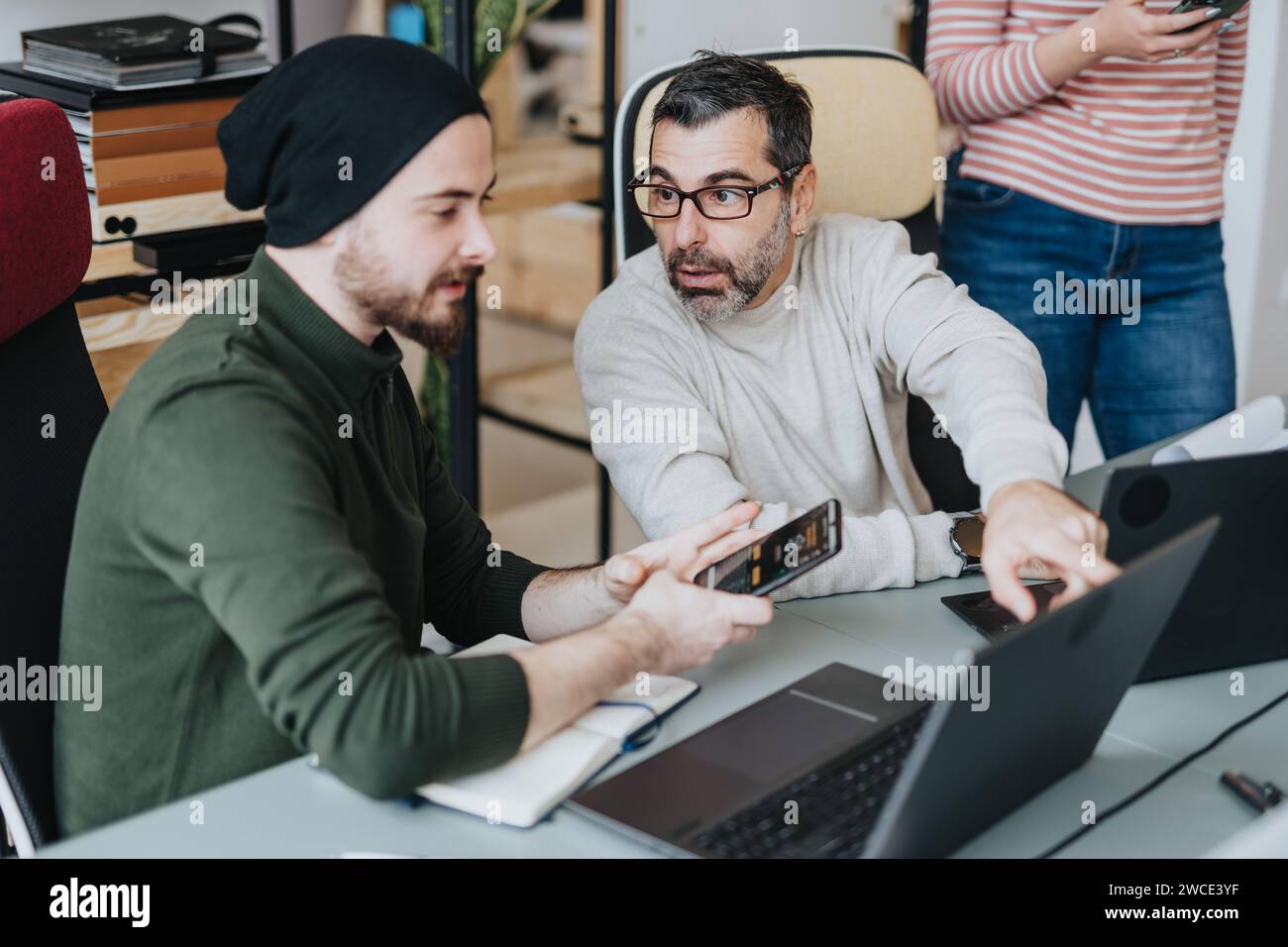 Multi generational coworkers collaborating in a modern office ...