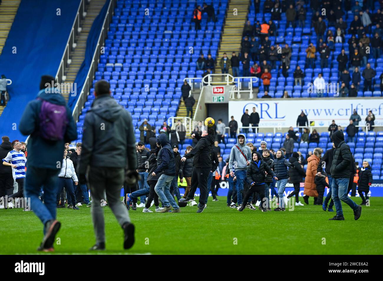 Reading, UK, 13th January 2024. Reading fans are seen playing with one of the match balls during the pitch invasion protesting the club's ownership. The EFL League One football match at home to Port Vale is later abandoned as supporters refuse to leave the pitch. Credit: TeeGeePix/Alamy Live News Stock Photo