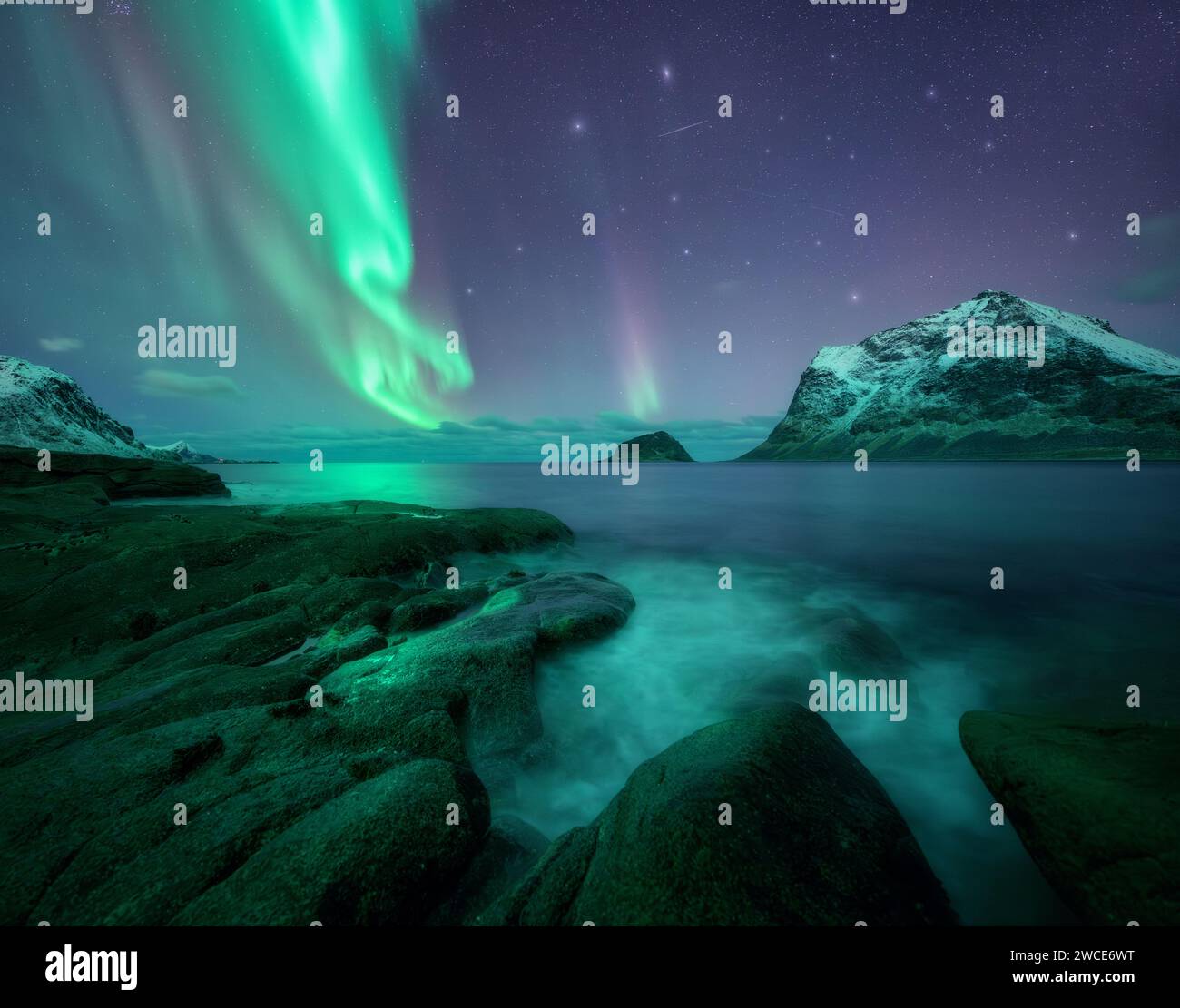 Aurora borealis over the sea, snowy mountains at starry night Stock ...