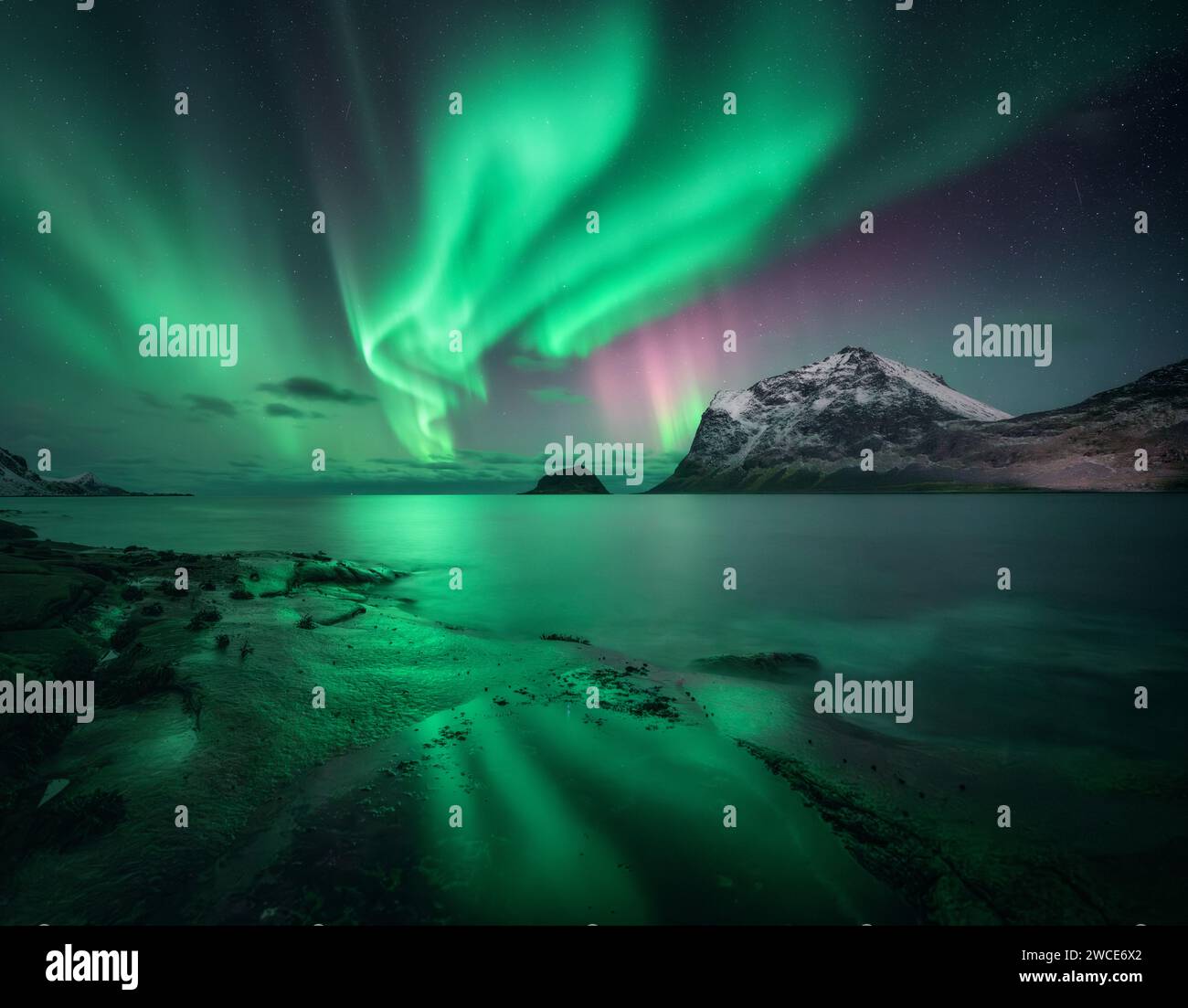 Aurora borealis over the sea, snowy mountains at starry night Stock ...