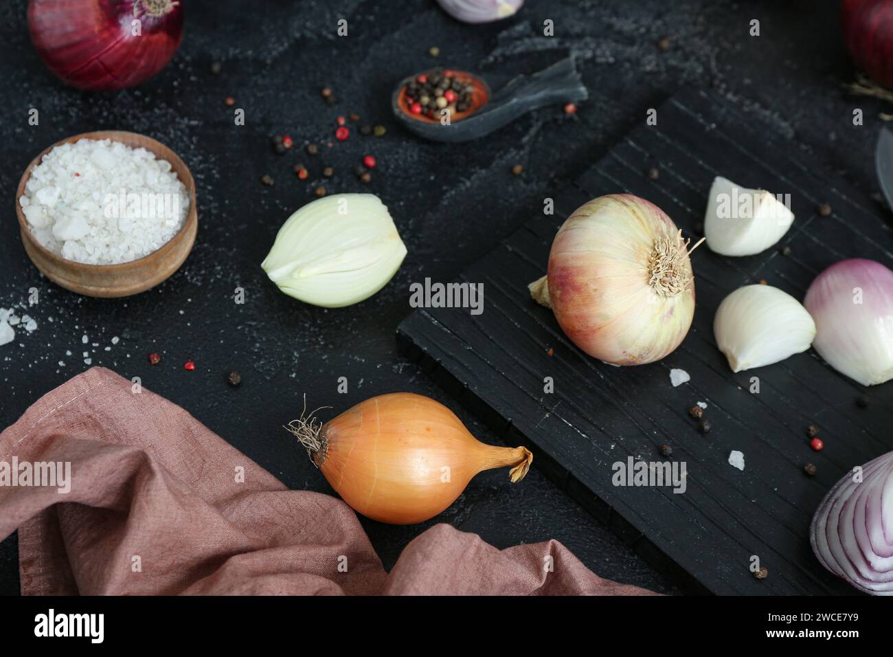 Board with different kinds of onion on grunge black background Stock ...
