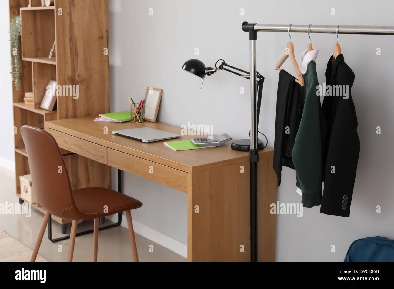 Interior of stylish room with modern workplace and school uniform on ...