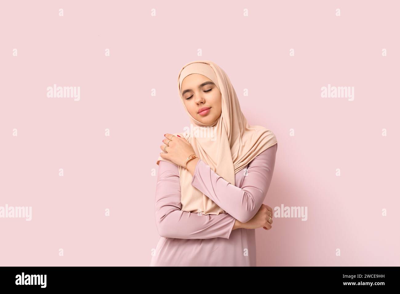 Beautiful young Muslim woman in hijab on pink background Stock Photo ...