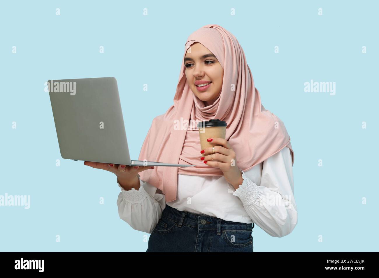 Beautiful young Muslim woman in hijab with paper cup of hot coffee and ...