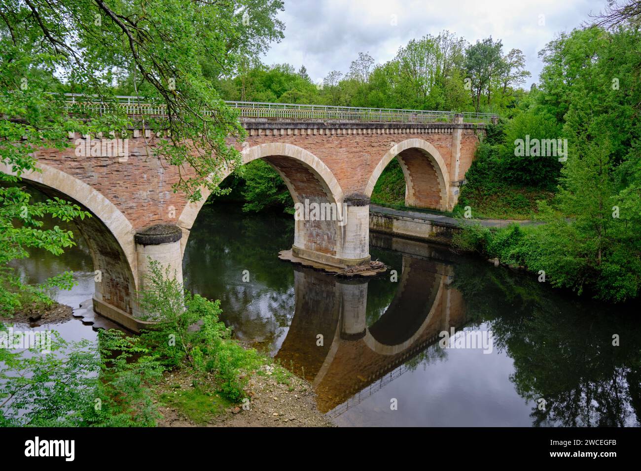 Vintage arched rail bridge, as it crosses the Thoré river, just outside ...