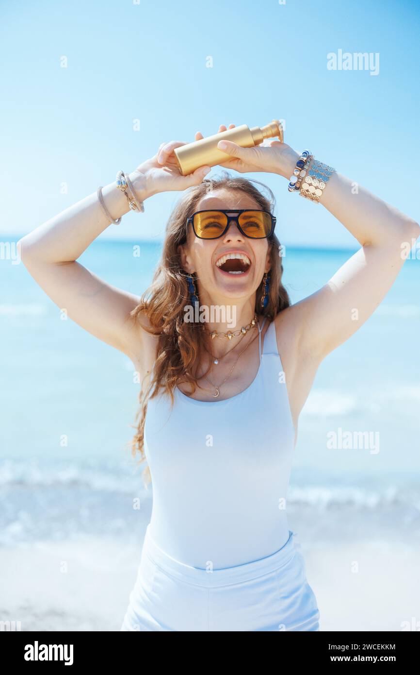 smiling elegant 40 years old woman on the ocean coast with spf. Stock Photo
