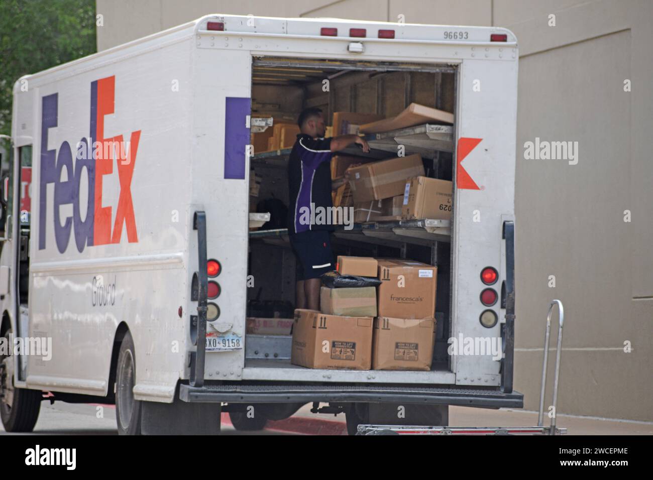 A FedEx delivery truck parked in Southlake, TX; a driver prepares to deliver packages to a business in Southlake Town Square Stock Photo