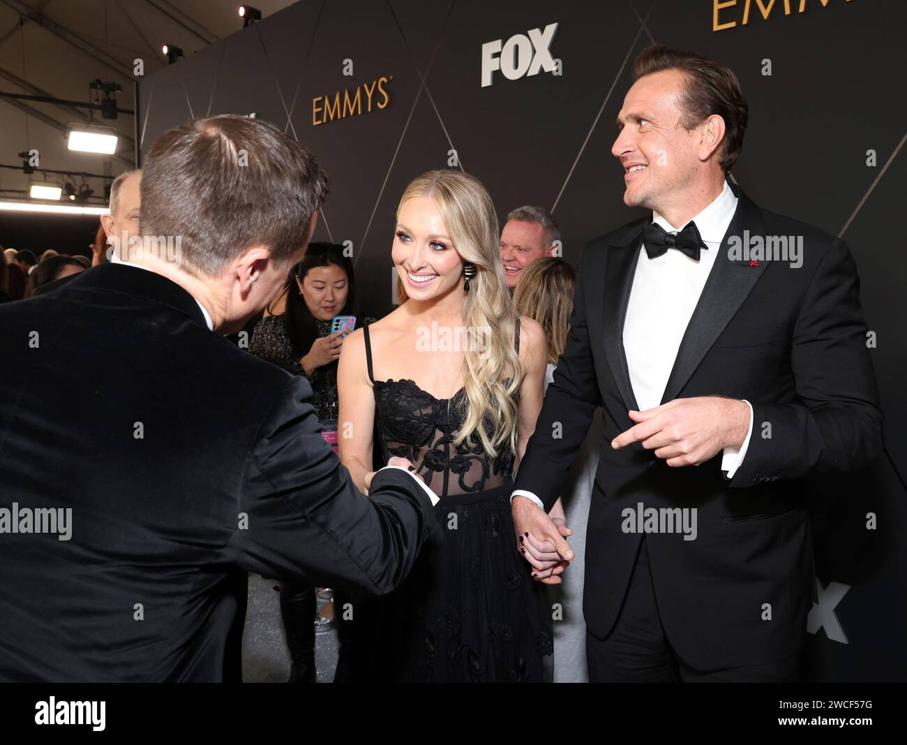 Kayla Radomski and Jason Segel walk the red carpet at the 75th Emmy