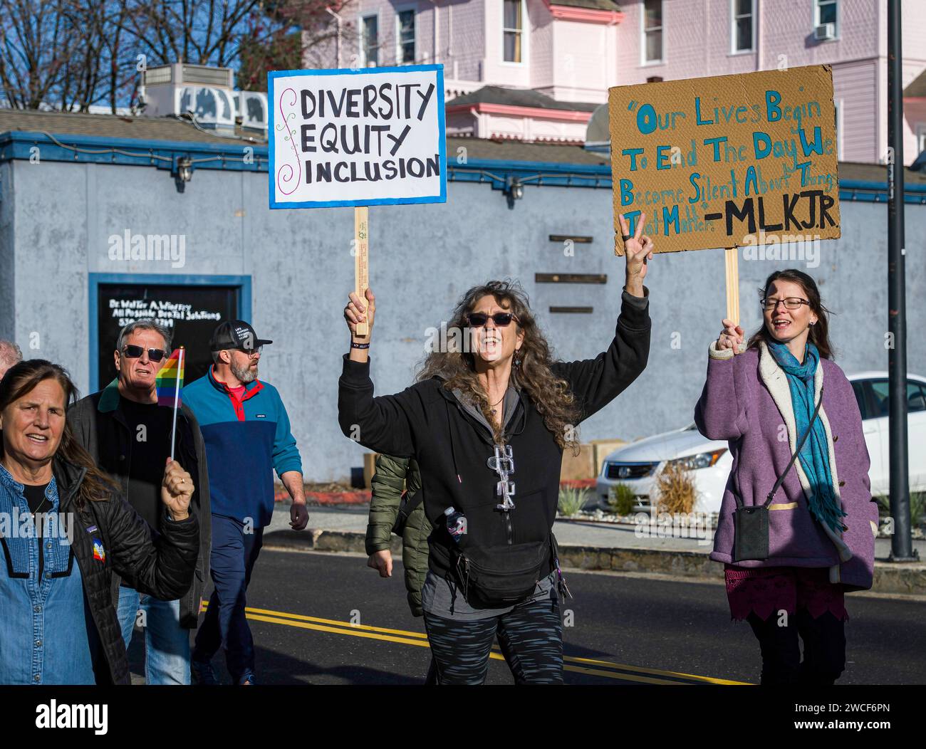 A woman with a sign about diversity, equity and inclusion marches with