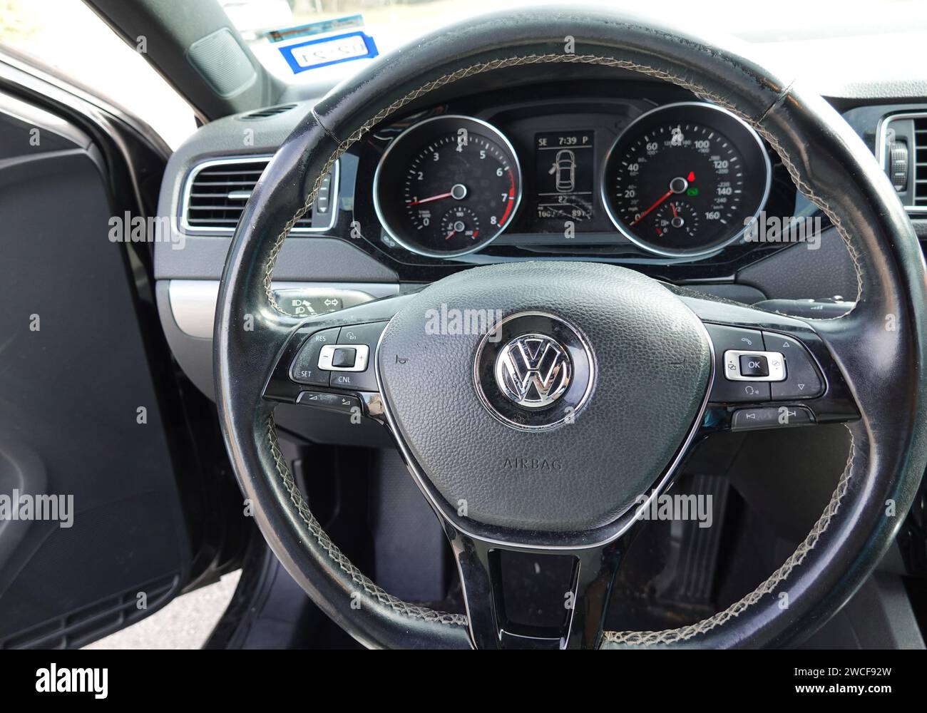 Steering wheel and interior of a black Volkswagen Jetta automobile