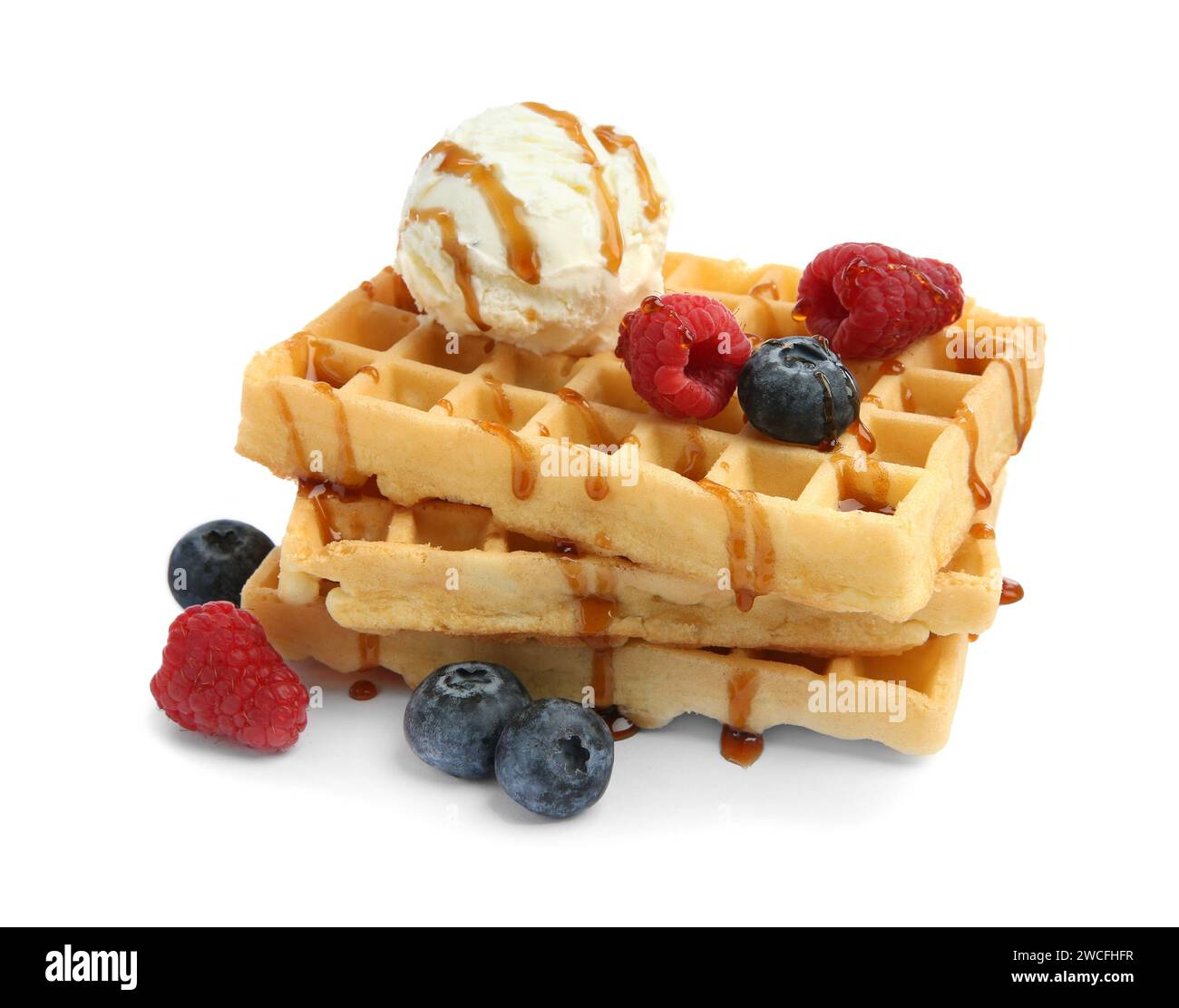 Tasty Belgian waffles with ice cream, berries and caramel syrup on ...