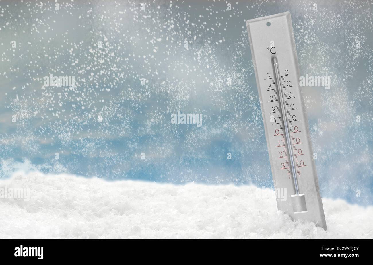 Thermometer in snow showing temperature below zero outdoors on winter day Stock Photo