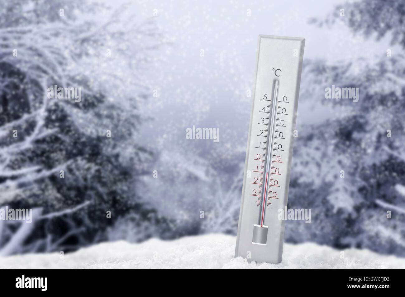 Thermometer in snow showing temperature below zero outdoors on winter day Stock Photo