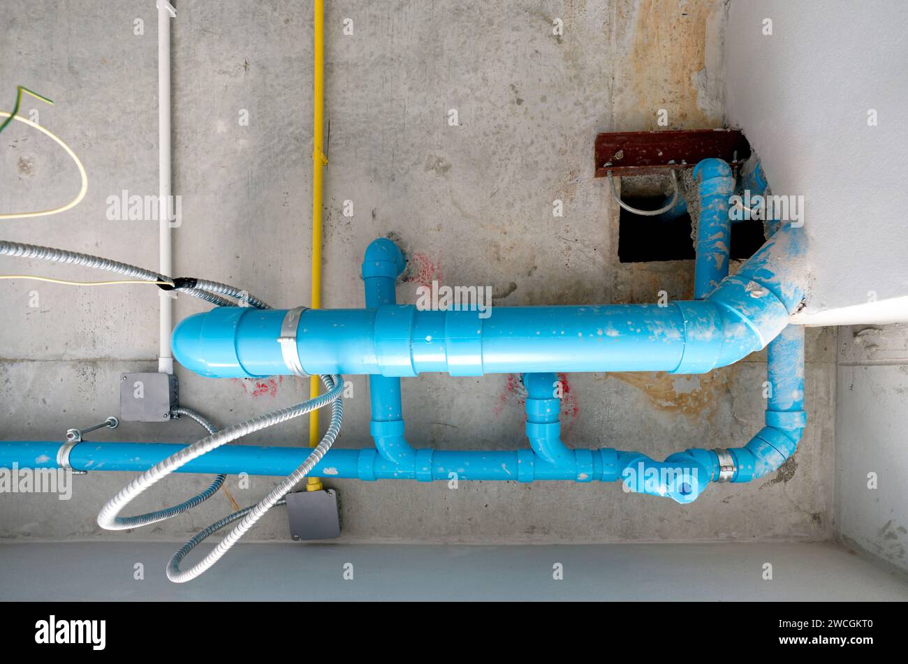 The water pipe system, wastewater pipes and electrical wiring are neatly installed under the ceiling. Stock Photo