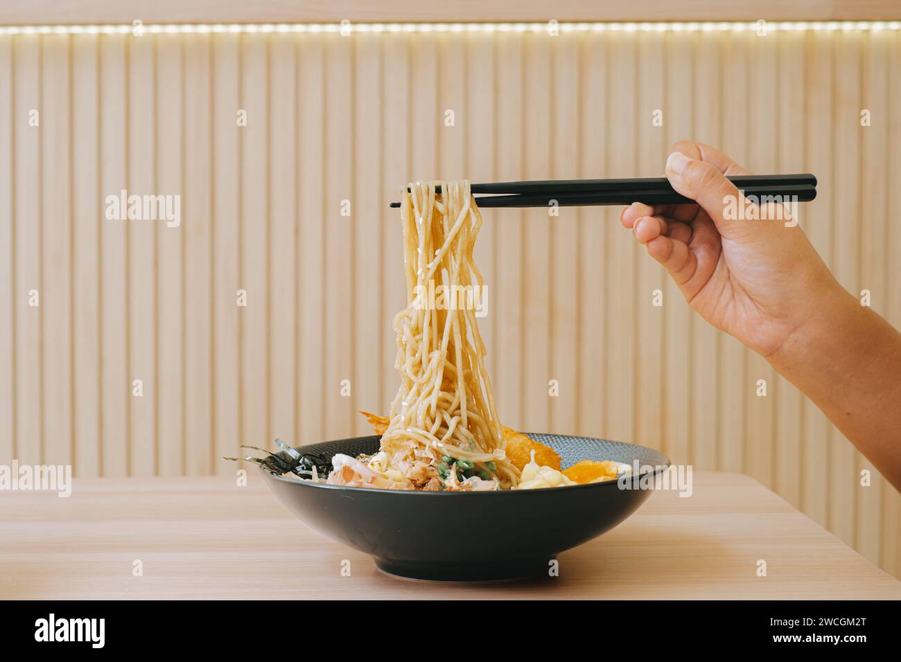 Hand takes Yaki Ramen using black chopsticks for food in Japanese