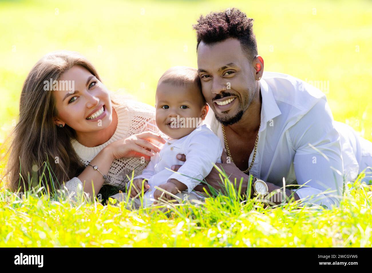 Multiethnic parents and mixed race baby in park. Multiracial family