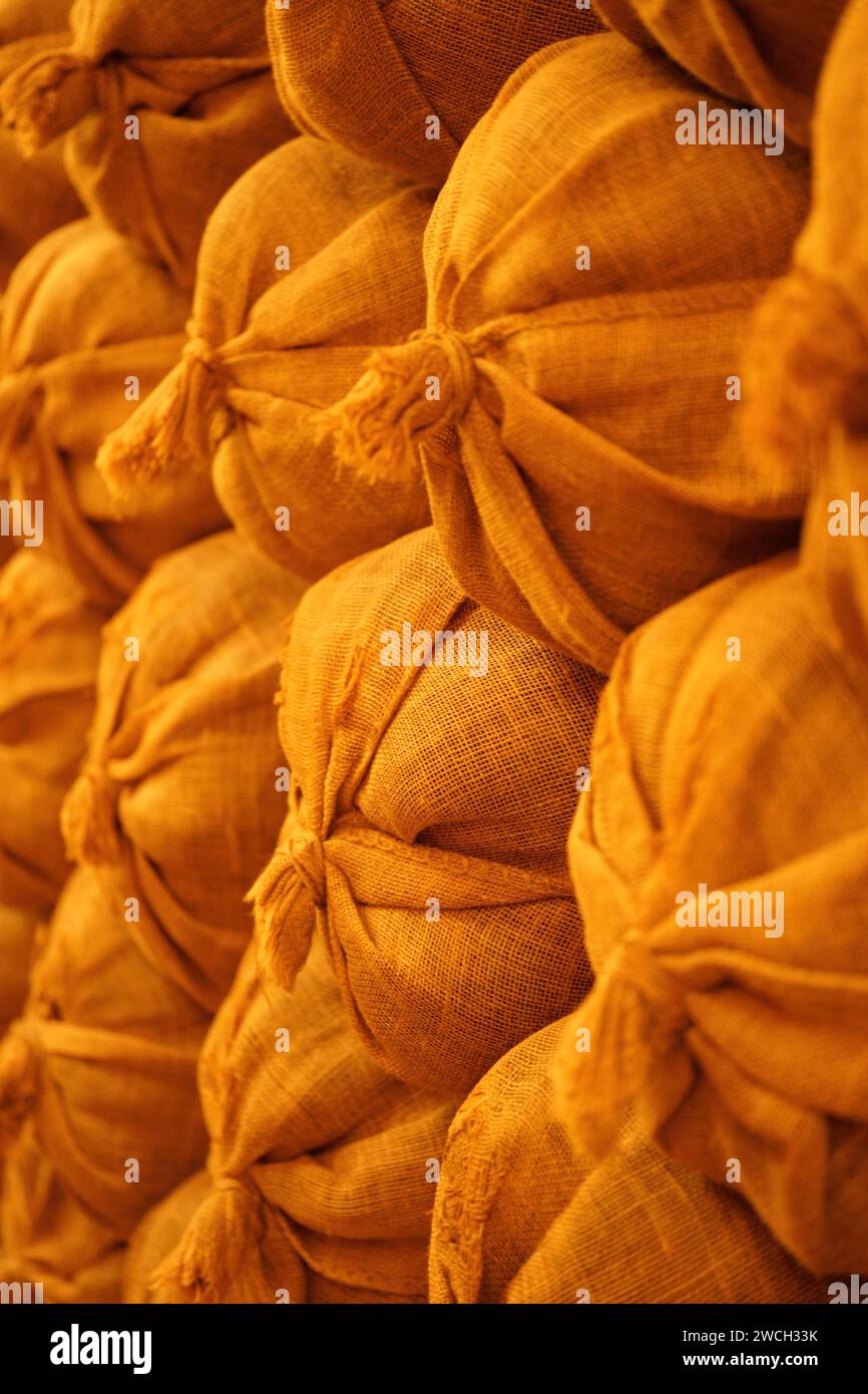 A variety of sack-shaped bags neatly arranged on a wall Stock Photo