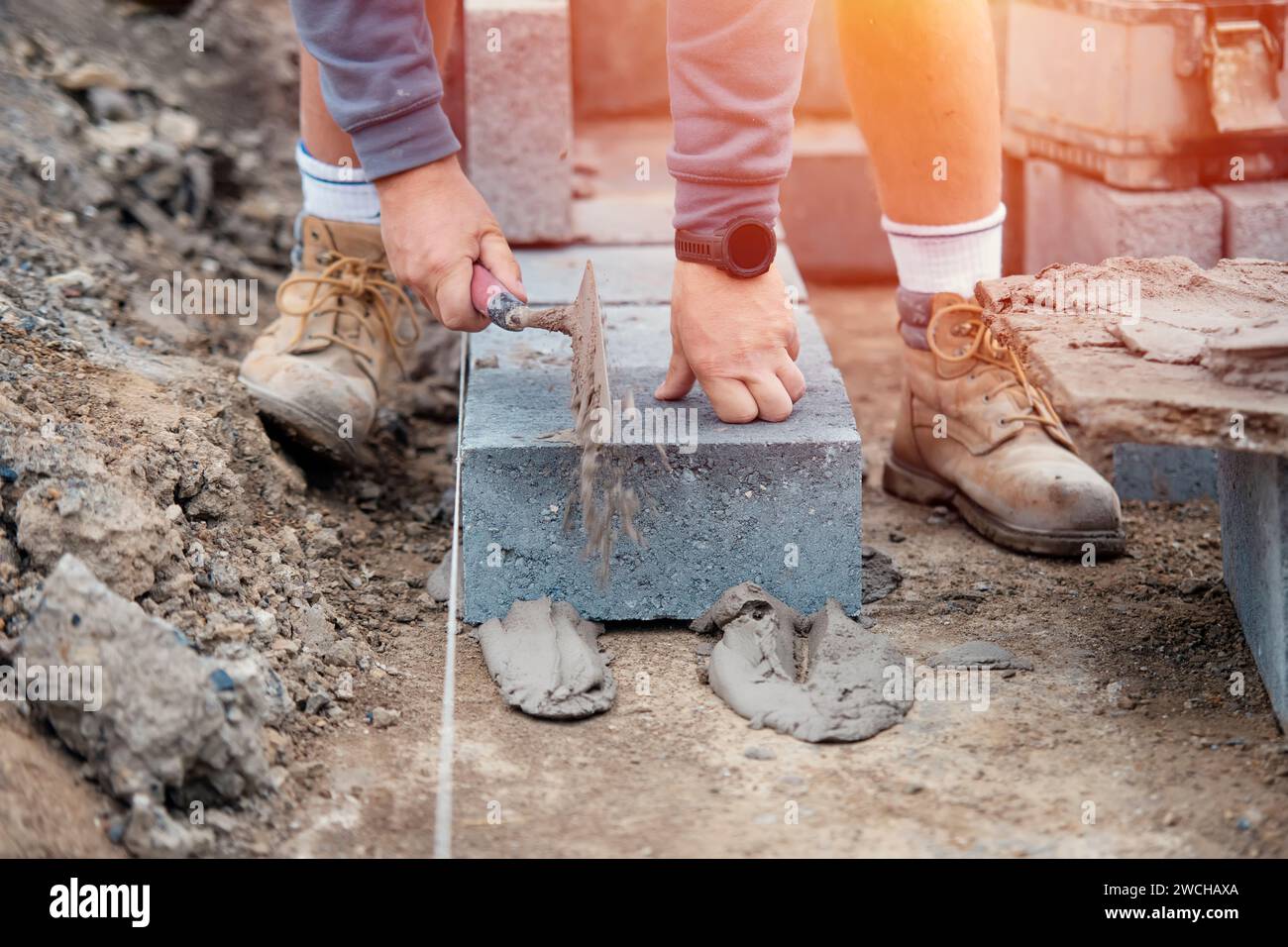 Bricklayer laying highdensity footing concrete blocks Stock Photo Alamy