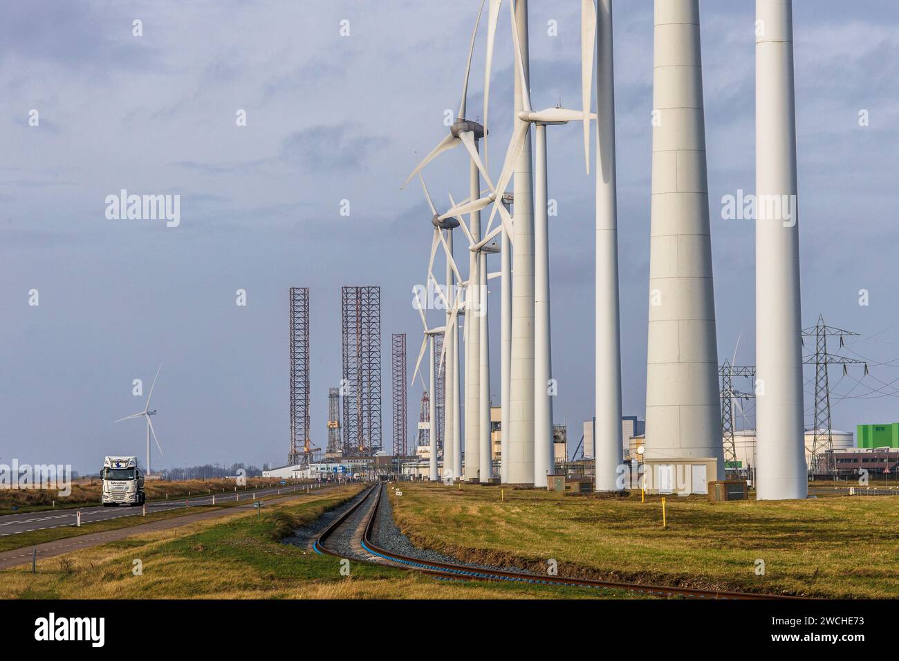 wind turbines at the port of Vlissingen, in the background an old disused oil drilling rig, Walcheren, Zeeland, Netherlands.  Windraeder im Hafen von Stock Photo
