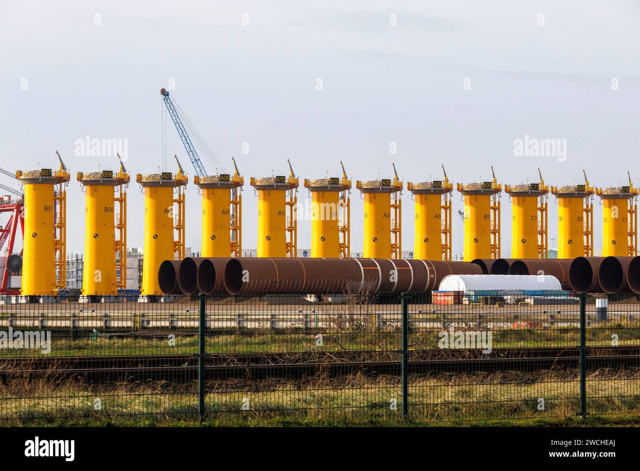 foundations for offshore wind turbines are stored in the port of Vlissingen, Walcheren, Zeeland, Netherlands.  Fundamente fuer Offshore Windkraftanlag Stock Photo