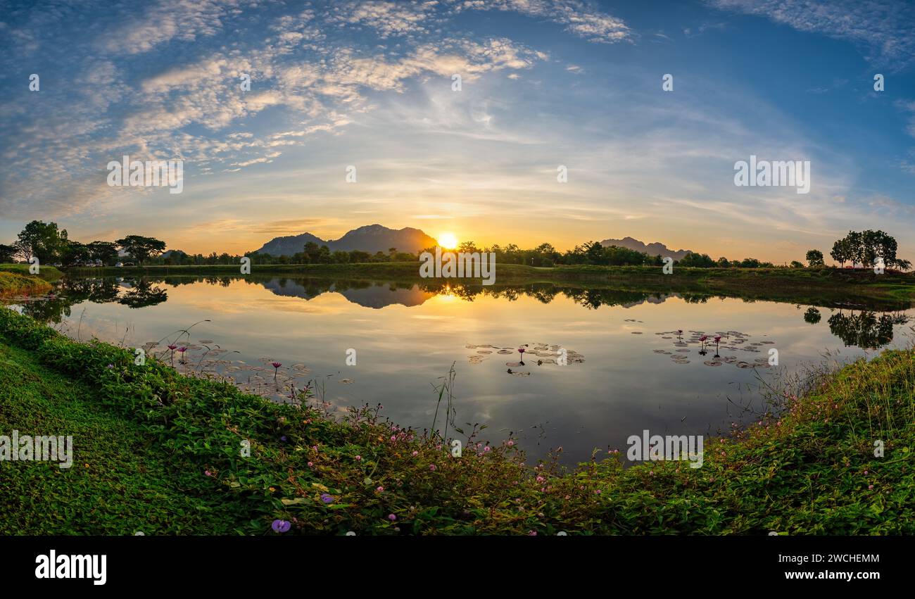 Tropical forest nature landscape with mountain range and pond water sunrise at Mae Moh mine, Lampang Thailand panorama Stock Photo