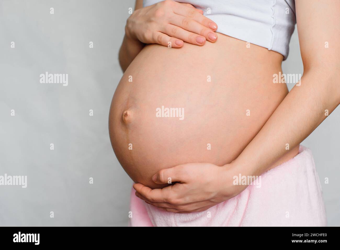 pregnant girl gently hugging her belly close-up Stock Photo - Alamy