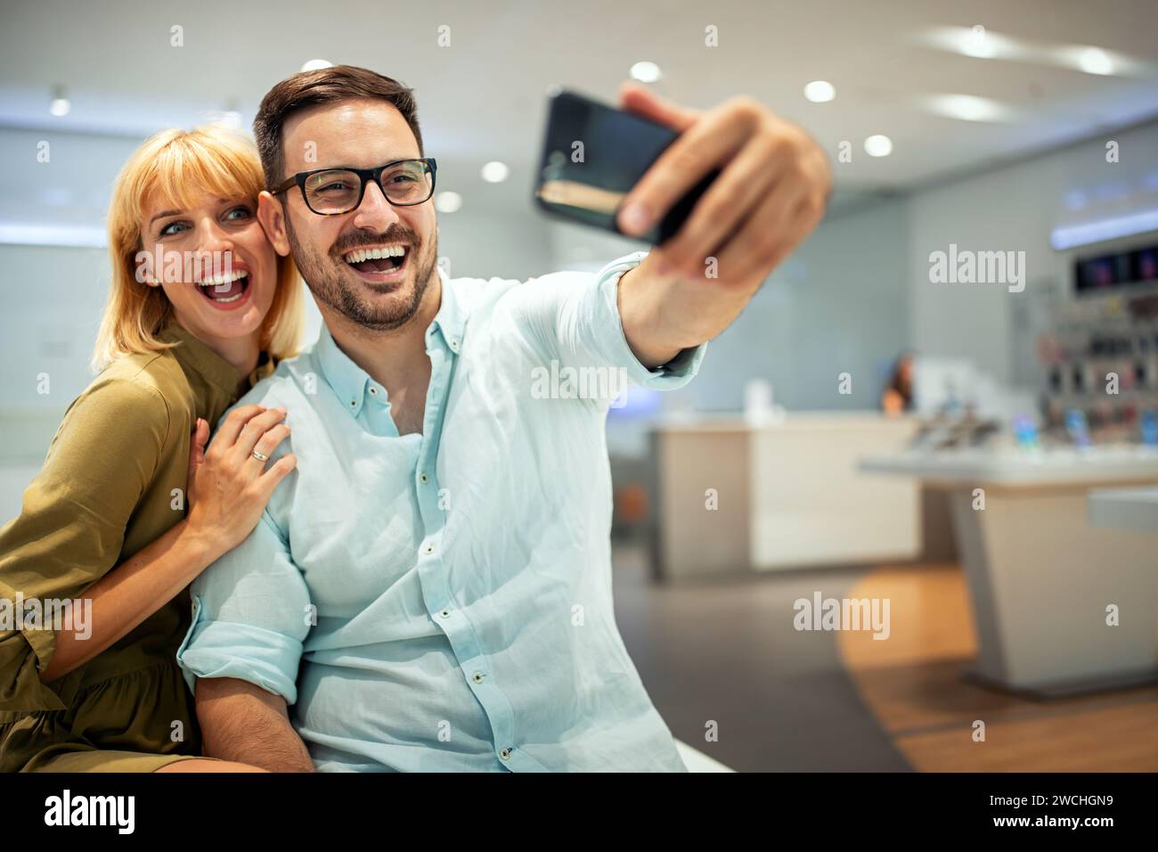 Couple is making selfie using a smart phone. Digital device, artificial intelligence concept. Stock Photo
