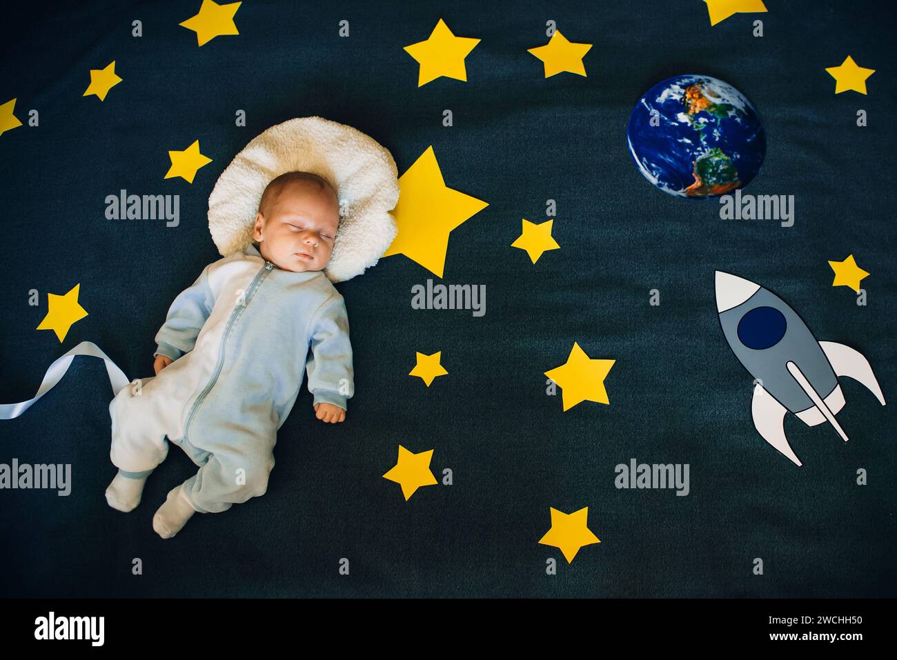 baby sleep of an astronaut in space with stars and a rocket Stock Photo Alamy