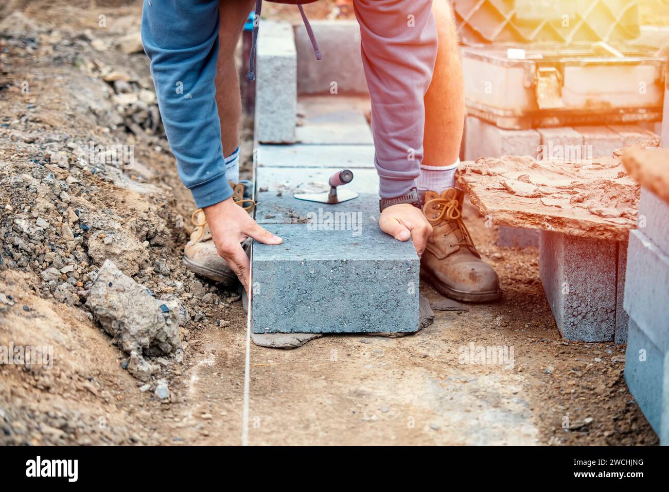 Bricklayer laying highdensity footing concrete blocks Stock Photo Alamy