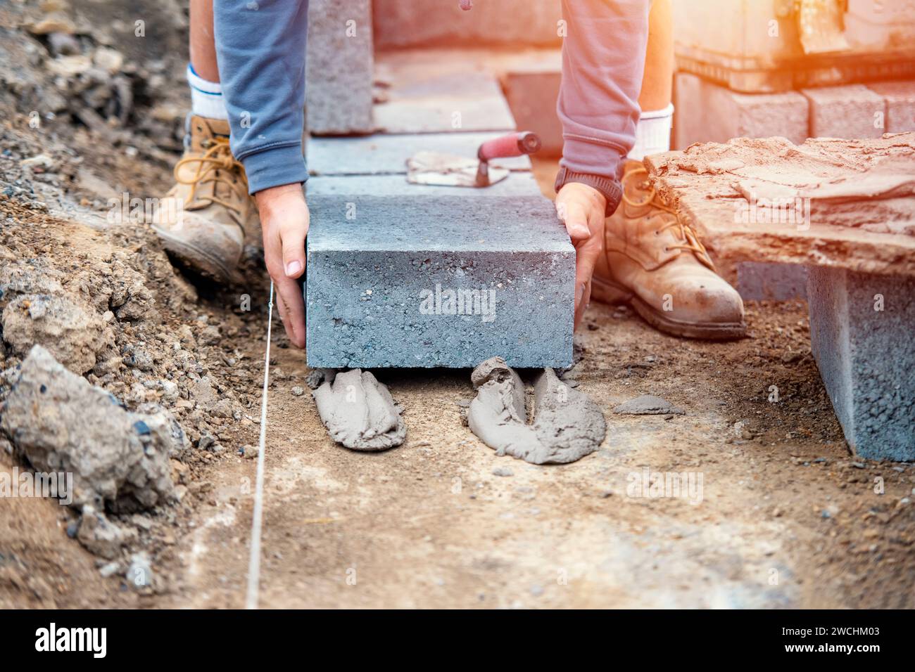 Bricklayer laying highdensity footing concrete blocks Stock Photo Alamy