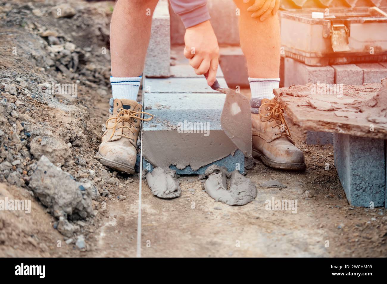 Bricklayer laying highdensity footing concrete blocks Stock Photo Alamy