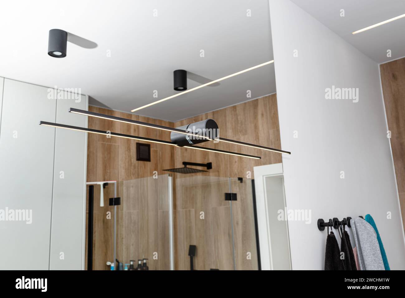 LED light strips mounted in the wall in a modern bathroom, visible black wall lamp Stock Photo