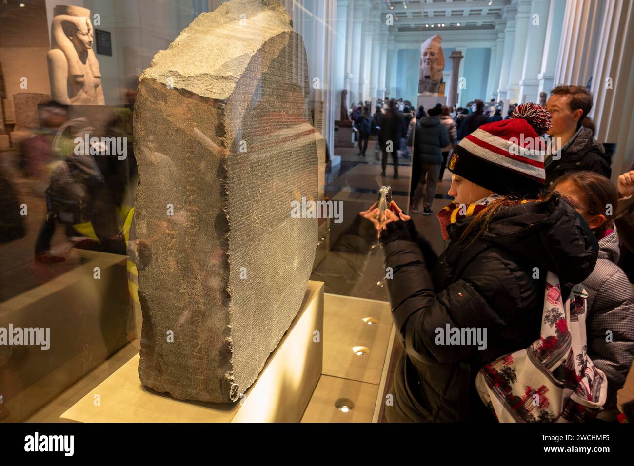 Visitors looking at the Rosetta Stone at the British Museum on 4th December 2023 in London, United Kingdom. The British Museum is a public museum dedicated to human history, art and culture located in the Bloomsbury area of London. It has a permanent collection of eight million works and is among the largest and most comprehensive collection, which documents the story of human culture from its beginnings to the present. Stock Photo