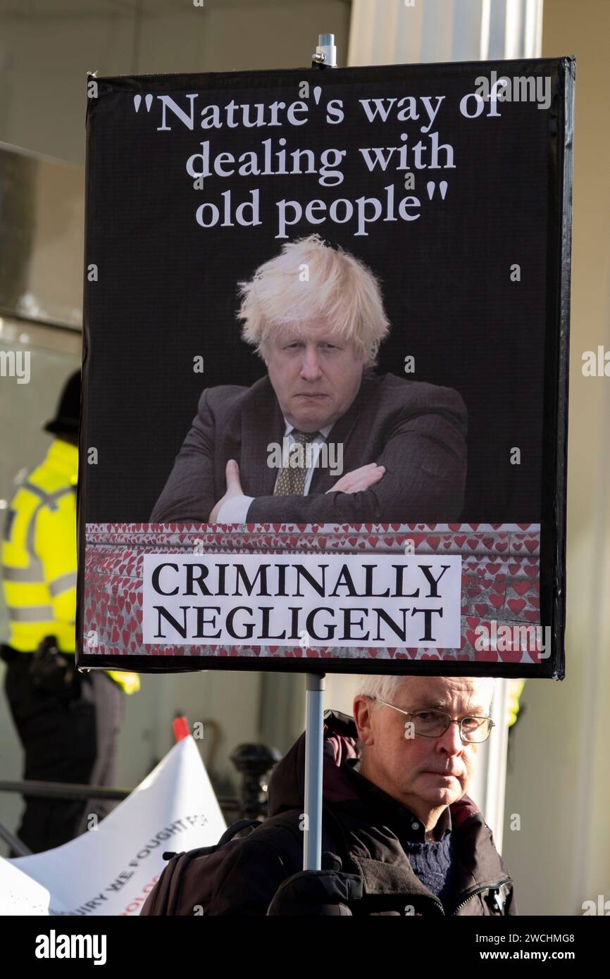 On the first day that Boris Johnson attended the UK Covid-19 Enquiry people protest outside holding placards featuring the former Prime Minister alongside slogans on 6th December 2023 in London, United Kingdom. The UK Covid-19 Inquiry is an independent public inquiry into the UK’s response to, and the impact of the coronavirus pandemic. Stock Photo