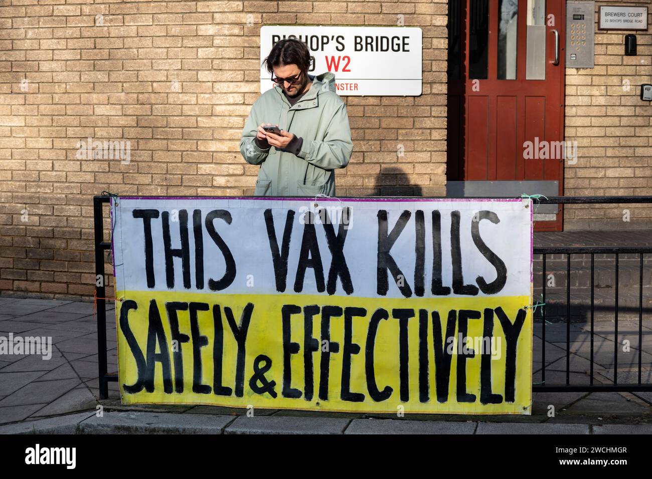 Anti-vax protesters holding yellow placards with anti vaccine slogans on the first day that former Prime Minister Boris Johnson attended the UK Covid-19 Enquiry on 6th December 2023 in London, United Kingdom. The UK Covid-19 Inquiry is an independent public inquiry into the UK’s response to, and the impact of the coronavirus pandemic. Vaccine hesitancy groups known as anti-vaxxers or anti vax, are generally against vaccination. Stock Photo