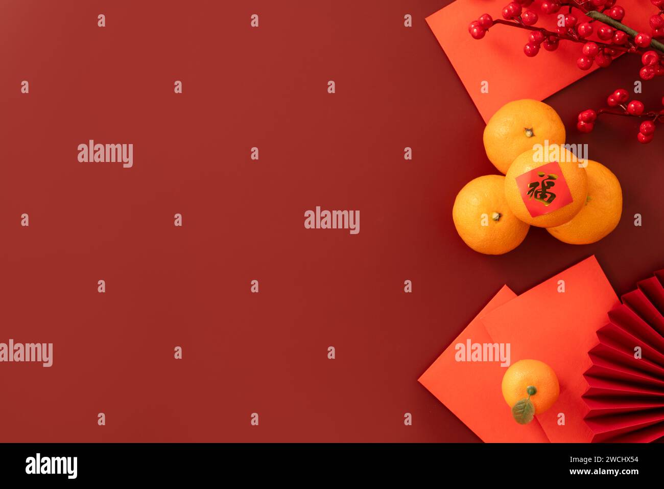 Chinese lunar new year background with fresh tangerine, red envelope, paper fan and decorations for Spring Festival and the word means fortune. Stock Photo