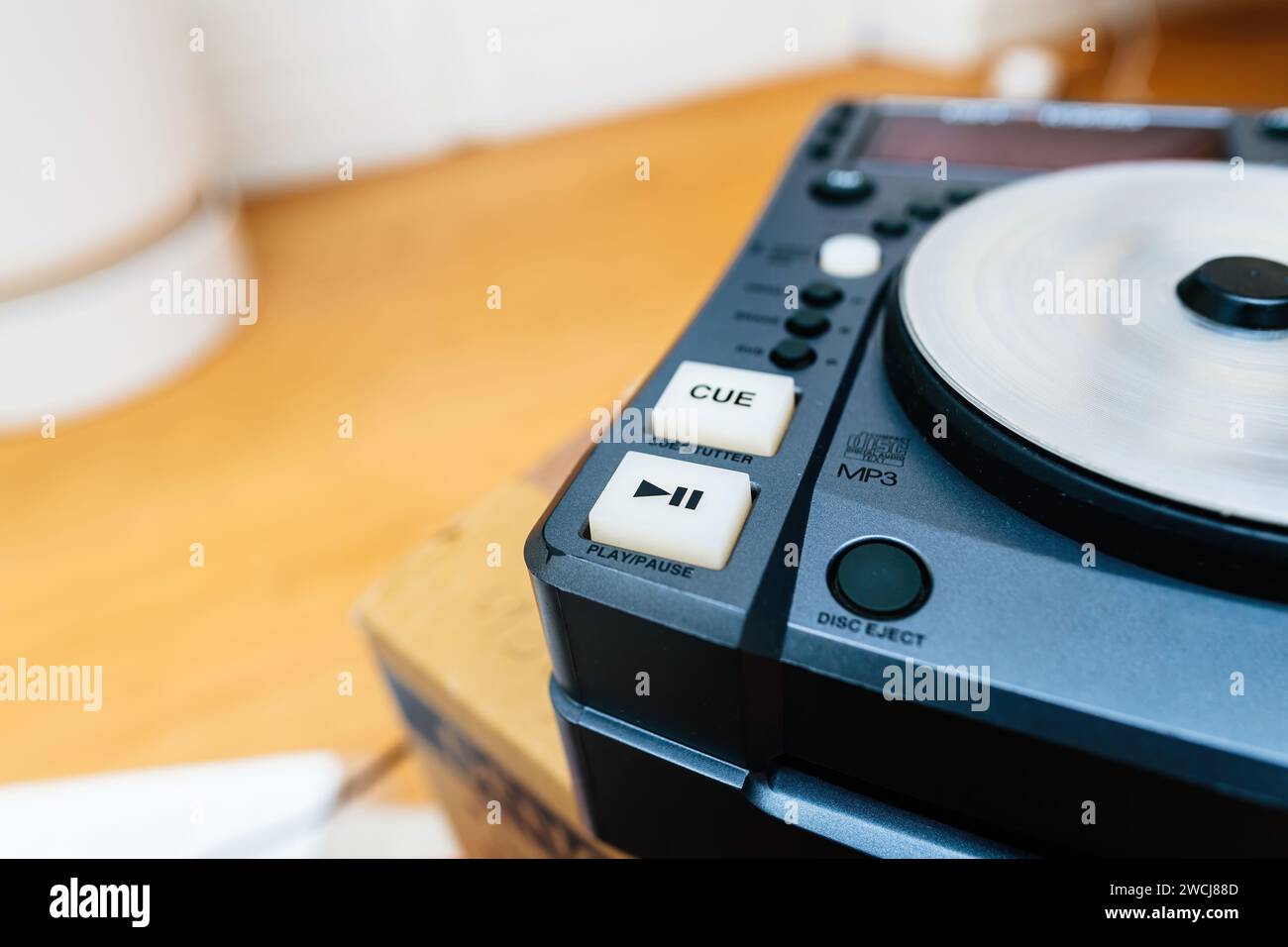 This image captures a closeup view of professional DJ equipment, focusing on the cue button and