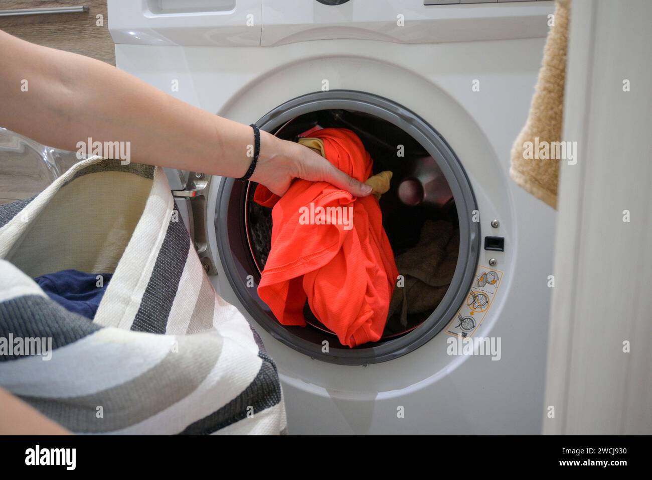 mom puts the laundry in the washing machine Stock Photo Alamy