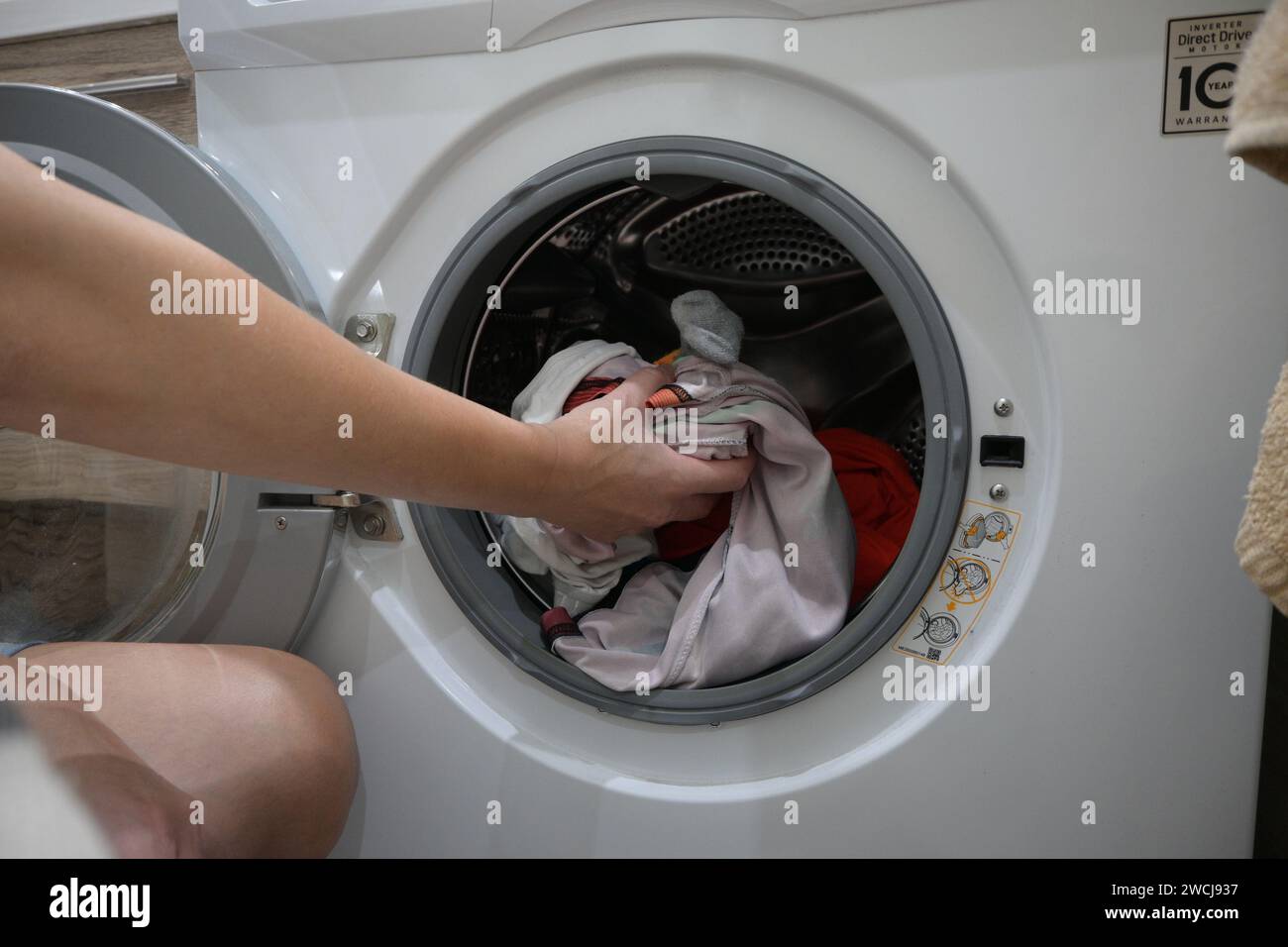 mom puts the laundry in the washing machine Stock Photo Alamy