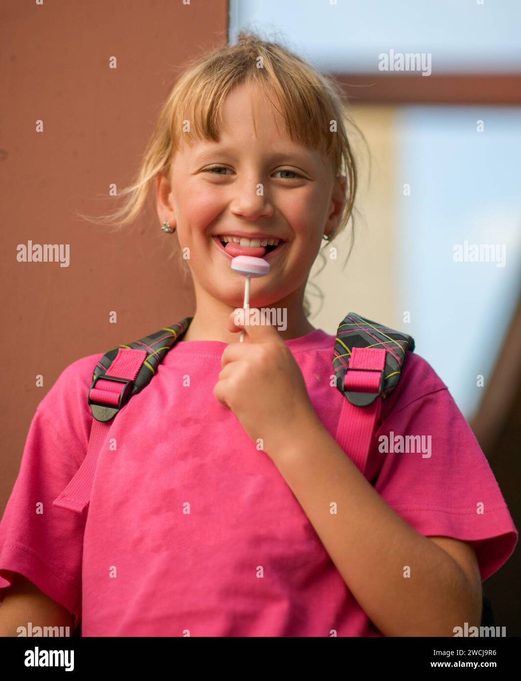 Little girl with a backpack on her back like a ski lollipop, blurred background. Stock Photo