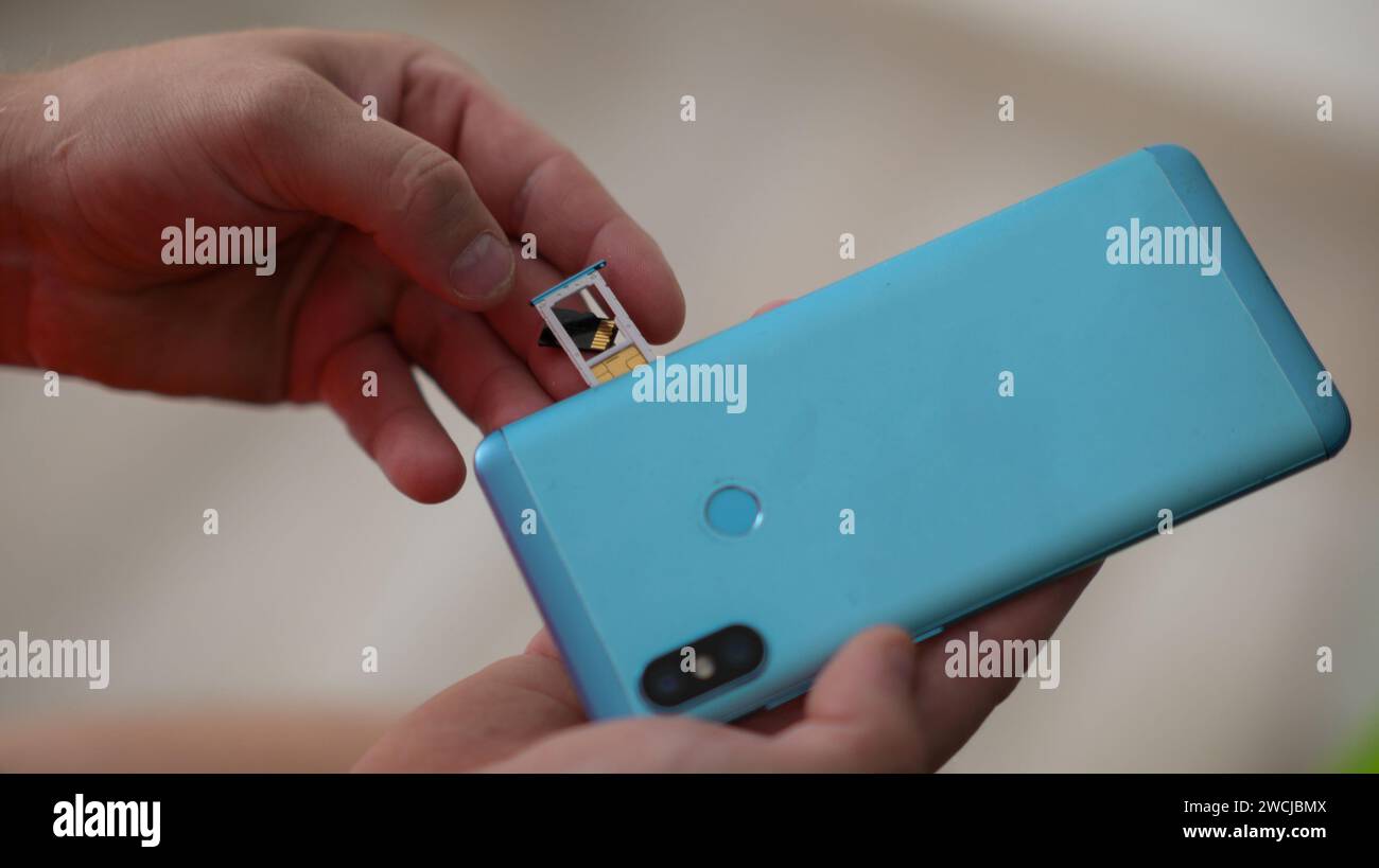 inserting a sim card into the phone, close-up view. Stock Photo