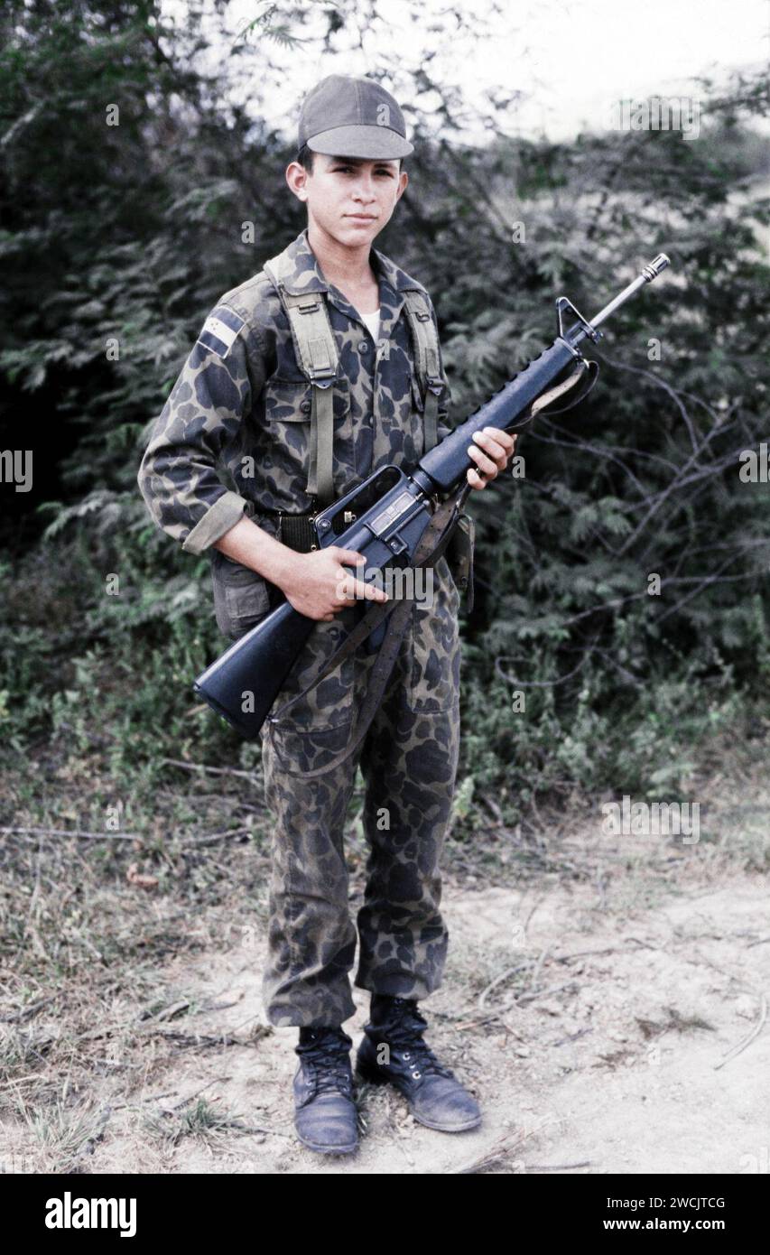 A fifteen year old Honduran soldier, stands guard at his post armed with an M16A1, 1983. Stock Photo