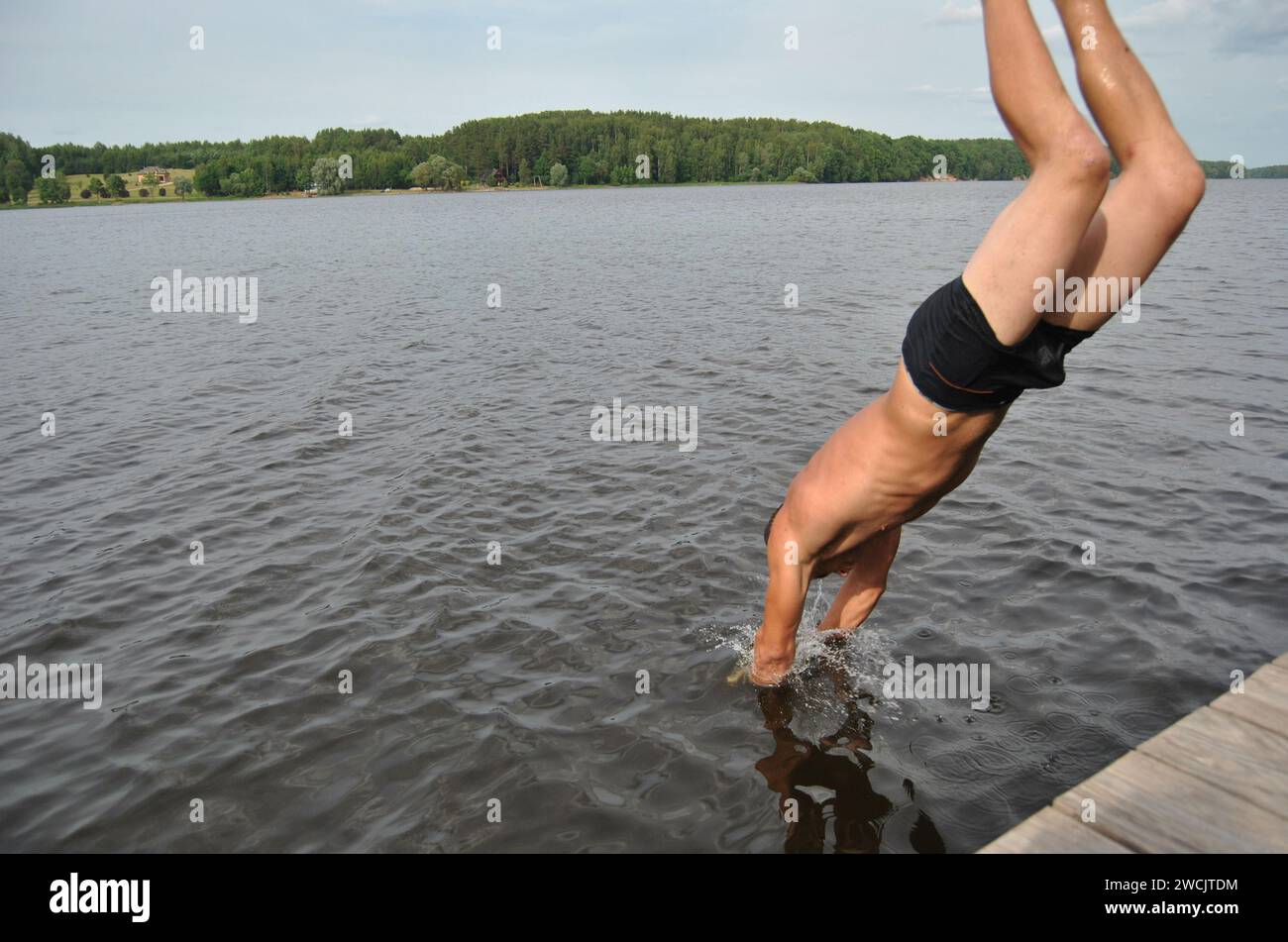 Man diving off a pier into the Daugava River in Sece, Latvia Stock Photo