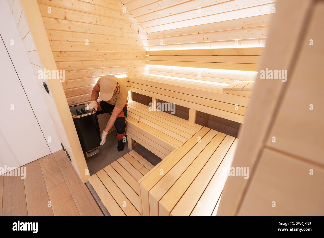 Caucasian Finnish Sauna Specialist in His 40s Installing Electric Sauna Heater Stock Photo