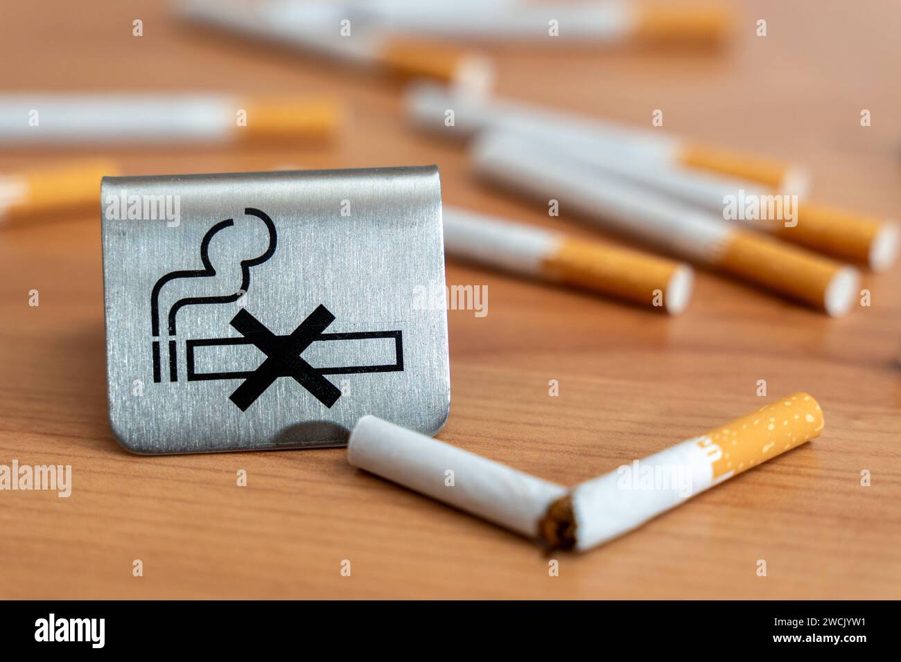Bavaria, Germany - January 6, 2024: Smoke-free concept, a no smoking sign next to a broken cigarette *** Rauchfrei Konzept, ein Rauchen verboten Schild neben einer zerbrochenen Zigarette Stock Photo