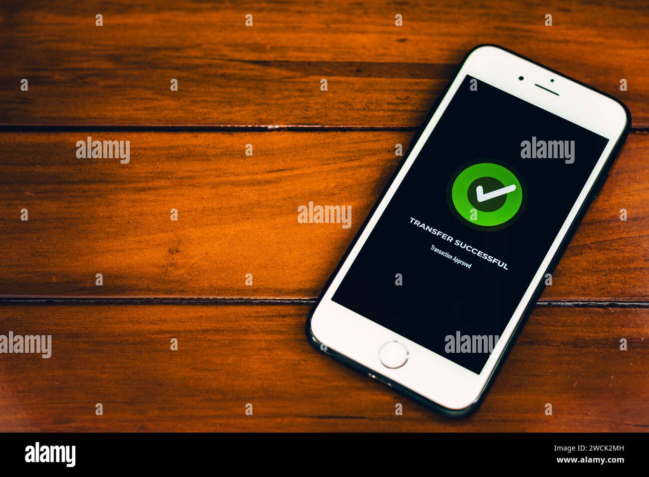 Money Transfers. Online payment. Smartphone with successful payment notification on screen on wooden background Stock Photo