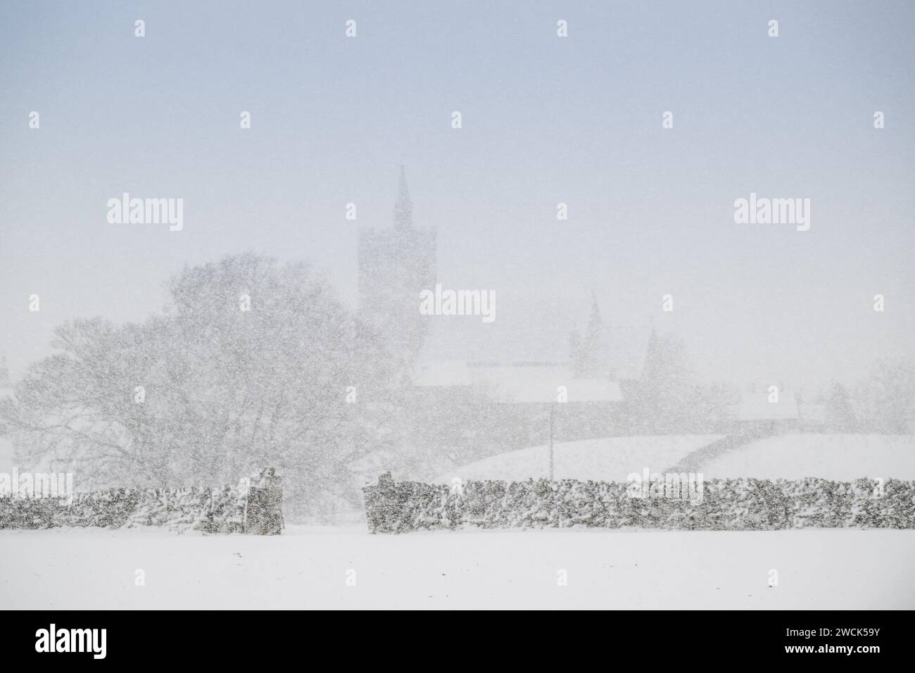 16th January 2024 - Weather - The parish church of St Margarets, Hawes, North Yorkshire, just visiblethrough the snow storm that engulfed the small Dales market town at the head of Wensleydale. Credit: Wayne HUTCHINSON/Alamy Live News Stock Photo